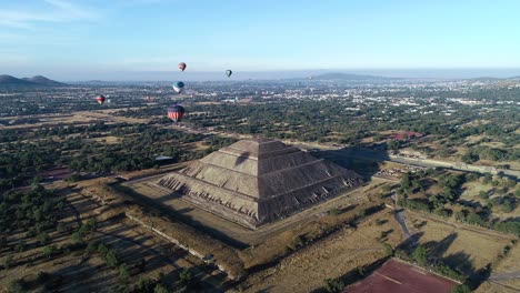 Aerial-view-of-balloon-riding-around-the-Pyramid-of-the-sun,-in-sunny-Teotihuacan,-Mexico---orbit,-drone-shot