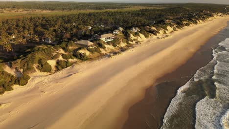 Descending-Aerial-Shot-Of-The-Beautiful-Beach-Houses-Looking-Onto-The-Shore-At-Tofo-Beach,-Mozambique