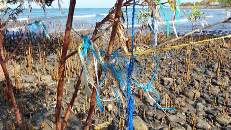 Discarded-waste-of-fishing-line,-ropes-and-plastic-bags-polluting-the-environment-of-ocean,-mangroves-and-shoreline-of-Southeast-Asian-country