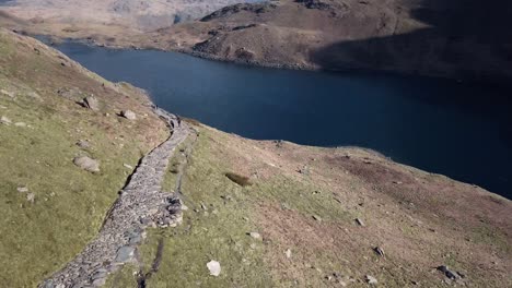 Video-Aéreo-Buceando-Por-La-Cara-Rocosa-De-La-Montaña-Hacia-El-Río-Azul