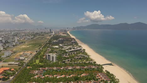 Aerial-view-of-long-white-sand-stretch-My-Khe,-My-Bac-An-and-Non-Nuoc-beach-with-mountains-on-sunny-day-in-Danang,-Central-Vietnam