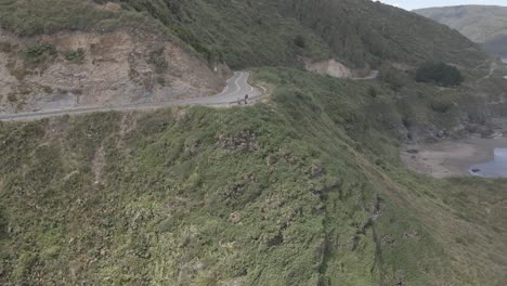 Aerial-push-out-shot-of-a-road-in-a-cliff-near-a-beach