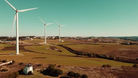 Three-Aligned-Wind-Turbines-Located-In-Marvelous-Green-Landscape,-Ericeira,-Portugal