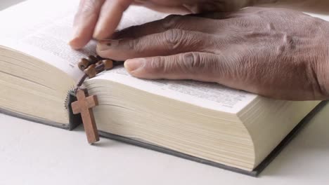 Beten-Zu-Gott-Mit-Der-Hand-Auf-Der-Bibel-Mit-Weißem-Tischstockmaterial