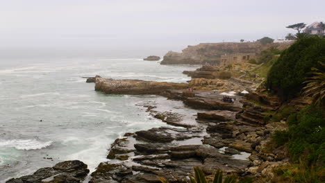 Rugged-Hermanus-coastline-on-misty-morning---people-whale-watching-from-rocks