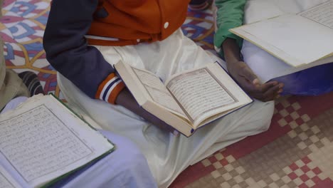 Draufsicht-Auf-Muslimische-Jungen,-Die-Zu-Hause-Den-Koran-Lesen