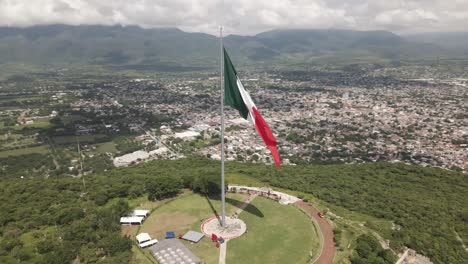 Aerial-spin-around-Mexican-flag-over-the-city-of-Iguala-in-the-state-of-Guerrero