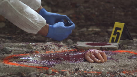A-detective-wearing-a-protective-suit-and-gloves-takes-pictures-of-the-gruesome-scene-with-the-severed-hand