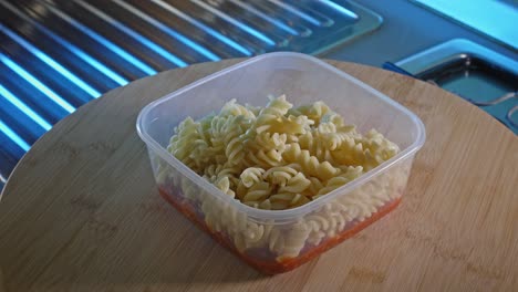Cooked-Rotini-Pasta-In-Food-Container-With-Spicy-Turkey-Bean-Sauce-At-The-Bottom