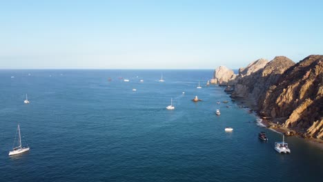 Many-boats-in-the-sea,-with-the-horizon-in-the-background,-next-to-mountains