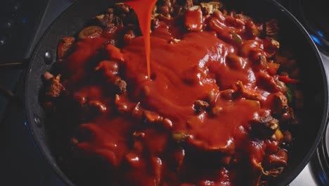 Verter-Salsa-De-Tomate-Rojo-En-Frijoles-De-Pollo-Picantes-Cocinados-En-Una-Sartén-Y-Revolver