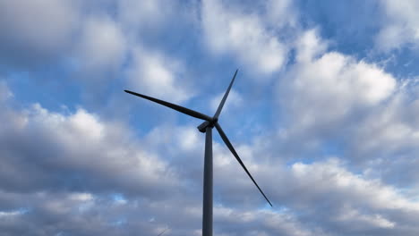 Single-lonely-wind-turbine-center-screen-with-fluffy-white-clouds
