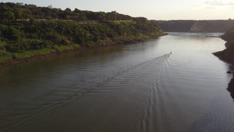 Aerial-view-of-boat-cruising-on-Iguazu-River-meeting-Rio-Parana-and-Triple-Border-between-Argentina,Brazil-and-Paraguay