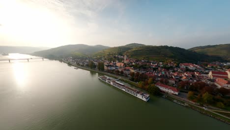 Peaceful-aerial-shot-of-the-cities-Krems-and-Stein-in-lower-Austria,-filmed-with-an-FPV-hovering-over-the-Danube