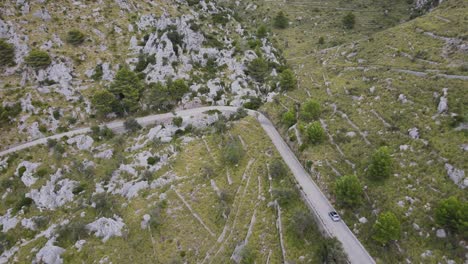 Close-up-shot-of-a-car-approaching-a-corner-on-a-mountain-road-at-Sa-Calobra,-Mallorca,-Spain