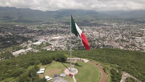 Langsame-Luftaufnahme-Der-Wehenden-Mexikanischen-Unabhängigkeitserklärungsflagge-über-Iguala