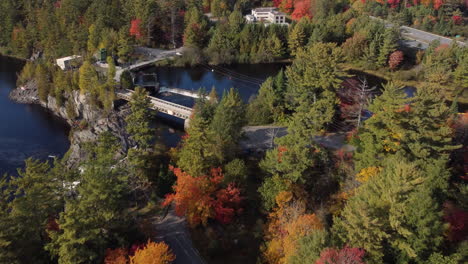 Drohnenflug-Zu-Einem-Wasserbecken-Mit-Wasserfall-über-Einem-Wald-In-Bunten-Herbstfarben
