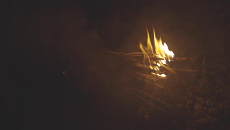 Slider-motion-shot-of-a-small-pile-of-sticks-burning-in-a-fire-pit