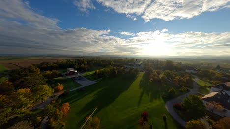 FPV-ascending-dynamically-over-Grafenegg-palace-garden-during-stunning-autumn-sunset