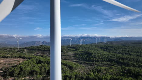 Extreme-close-up-on-wind-farm-turbine-with-views-over-mountainous-terrain
