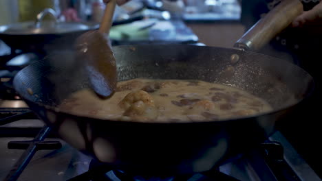 Prawns-Being-Stirred-In-Simmering-Bubbling-Sauce-Inside-Wok-With-Wooden-Spoon