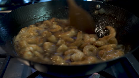 Prawns-Being-Stirred-In-Sauce-Inside-Wok-With-Wooden-Spoon