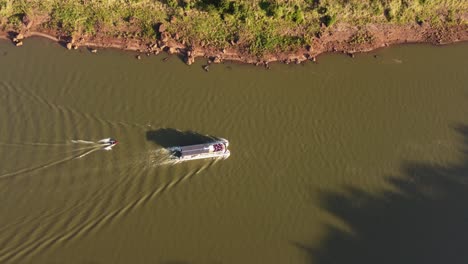 Two-boats-along-Iguazu-river-at-dusk,-border-between-Argentina-and-Brazil