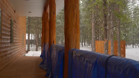 side-of-the-cabin-getting-snowed-on-by-a-heavy-but-slow-snow-storm-in-the-middle-of-the-pine-woods
