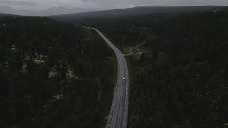 A-drone-shot-of-centered-road-leading-symmetrical-through-a-valley