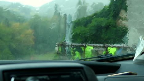 heavy-rain-falls-on-the-car-windshield-during-a-storm,-global-warming-concept