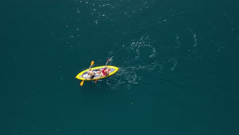 Close-up-aerial-of-a-yellow-sea-Kayak-with-2-people-paddling-together