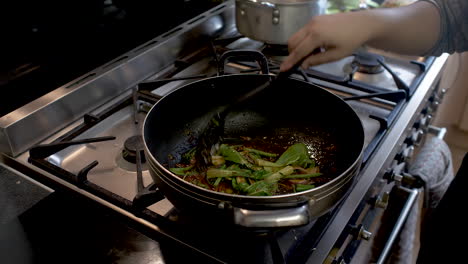Chef-Adding-Pak-Choi-Into-Wok-And-Stirring-It-In-With-Chilli-Paste