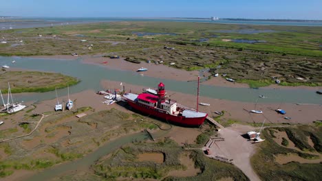 Converted-Lightvessel-Trinity-Of-Fellowship-Afloat-Charitable-Trust-Surrounded-By-Mud-Berths-And-Smaller-Vessels-In-Tollesbury,-Essex,-England