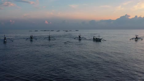 Antena-De-Muchos-Barcos-Turísticos-Persiguiendo-Delfines-En-El-Océano-Tropical-Al-Amanecer-En-Lovina-Bali-Indonesia