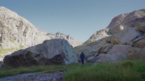 a-man-trekking-alone-between-the-rocks,-walking-towards-the-camera