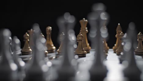 Shallow-depth-shot-from-behind-silver-chess-pieces-of-gold-pawn-moved-forward