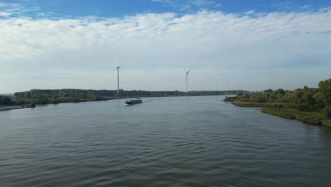 Luftaufnahme-über-Die-Oude-Maas-Mit-Sich-Näherndem-Binnentanker-Comus-2-Mit-Windmühlen-Im-Hintergrund