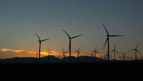 Silhouetten-Von-Windkraftanlagen-Mit-Skyline-Bei-Sonnenuntergang-Im-Hintergrund,-Grünes-Energiekonzept,-Statische-Aufnahme