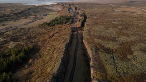 Avance-Aéreo-Sobre-Falla-O-Grieta-Del-Parque-Nacional-Thingvellir-Con-Cascada-Oxararfoss,-Islandia