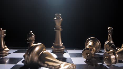 Gold-king-chess-piece-in-checkmate-toppled-over-after-defeat