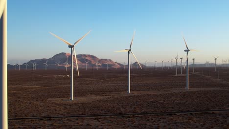 Turbinas-Eólicas-En-El-Desierto-De-Mojave-Durante-El-Día-Despejado,-Concepto-De-Energía-Alternativa,-Vista-Aérea-De-Drones
