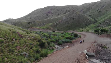 Aerial-shot-of-bike-riders-riding-on-a-rough-road-near-Khuzdar-in-Balochistan,-Pakistan