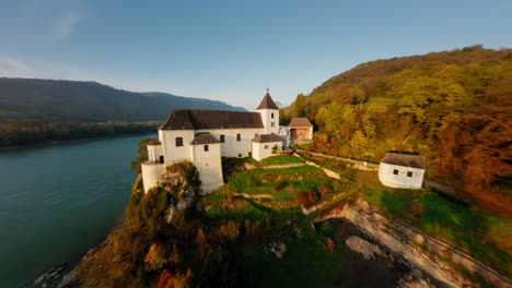 Slow-ascending-aerial-round-shot-of-stunning-monastery-Schönbühel-in-autumn-light