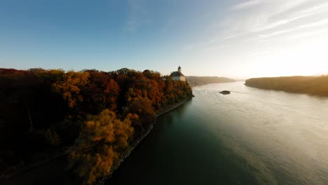 FPV-approaching-painterly-Schönbühel-castle,-slowly-ascending-and-passing-it-with-a-smooth-rotation,-revealing-the-peaceful-Danube-river