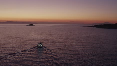 Aerial---Fishing-boat-at-dusk-in-Vouliagmeni,-Greece