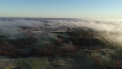 Aerial-forward-over-countryside-in-foggy-day