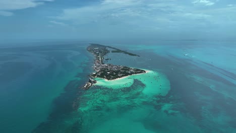 Aerial-view-towards-Isla-Mujeres-island,-in-sunny-Mexico---establishing,-drone-shot