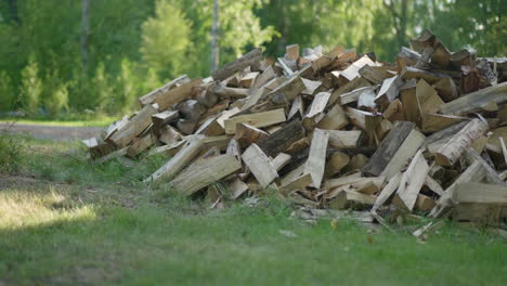 Slow-Panning-Shot-of-Wood-Flying-into-a-Pile-of-Firewood---Preparing-For-a-Cold-Winter