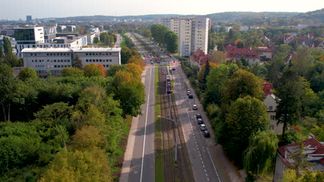 Long-straight-road-travelling-through-suburban-Oliwa-district-of-Gdansk-cityscape-aerial-reversing-view