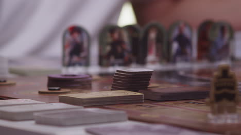 Putting-cards-on-table,-playing-desk-game,-closeup-view,-people-in-background